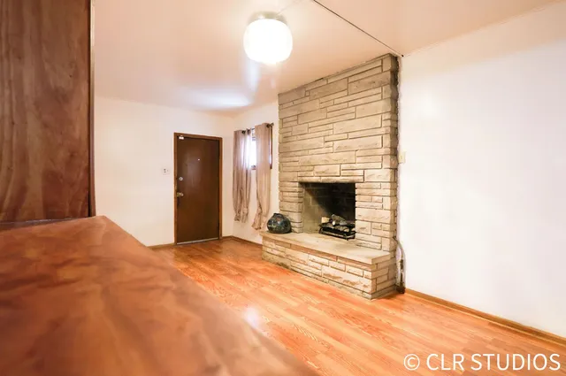 a view of empty room with fireplace and wooden floor