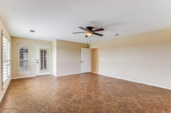 a view of an empty room with a ceiling fan