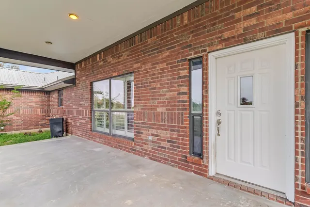 a view of an empty room with a fireplace and a window