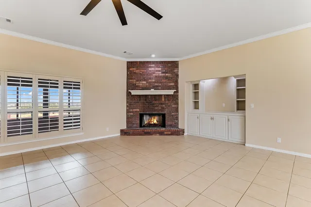 a view of an empty room with a fireplace and cabinet