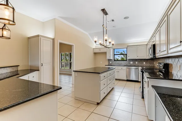 a kitchen with stainless steel appliances granite countertop a sink a stove and a refrigerator