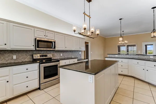 a kitchen with stainless steel appliances granite countertop a sink a stove a microwave and cabinets