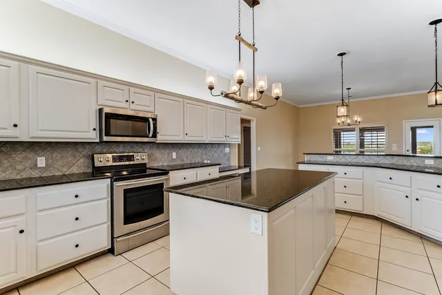 a kitchen with stainless steel appliances granite countertop a sink a stove a microwave and cabinets