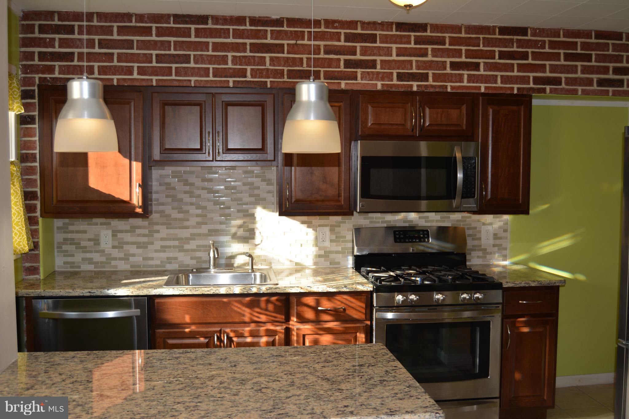 8004 Charlesmont Road Baltimore, MD 21222 - Photo 4 of 18 a kitchen with stainless steel appliances a stove and a microwave