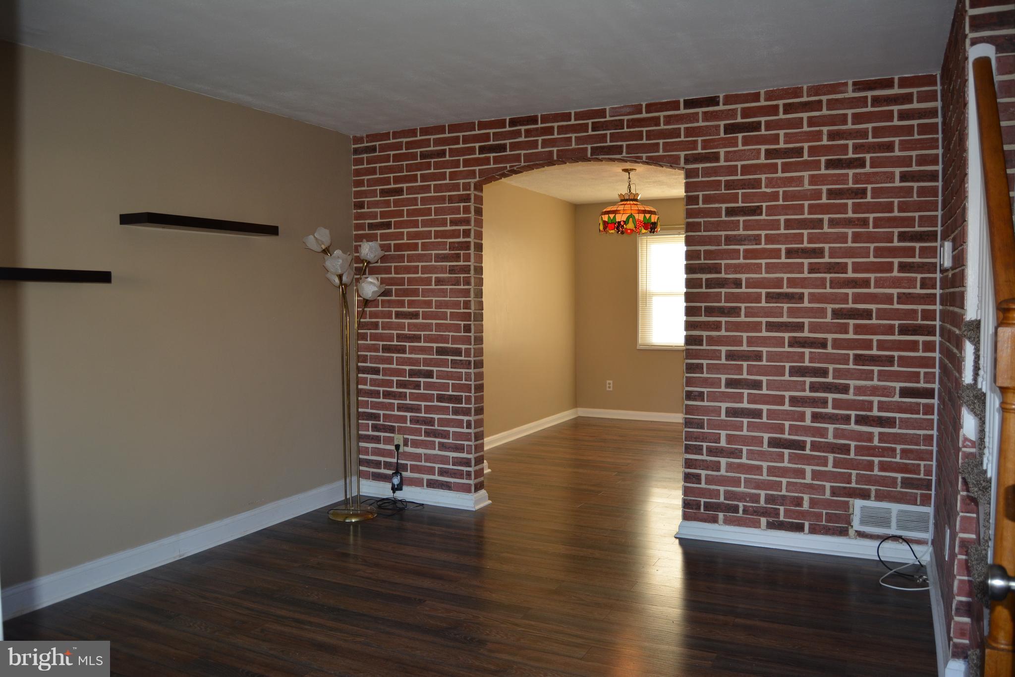 8004 Charlesmont Road Baltimore, MD 21222 - Photo 6 of 18 a view of an empty room with wooden floor and a window