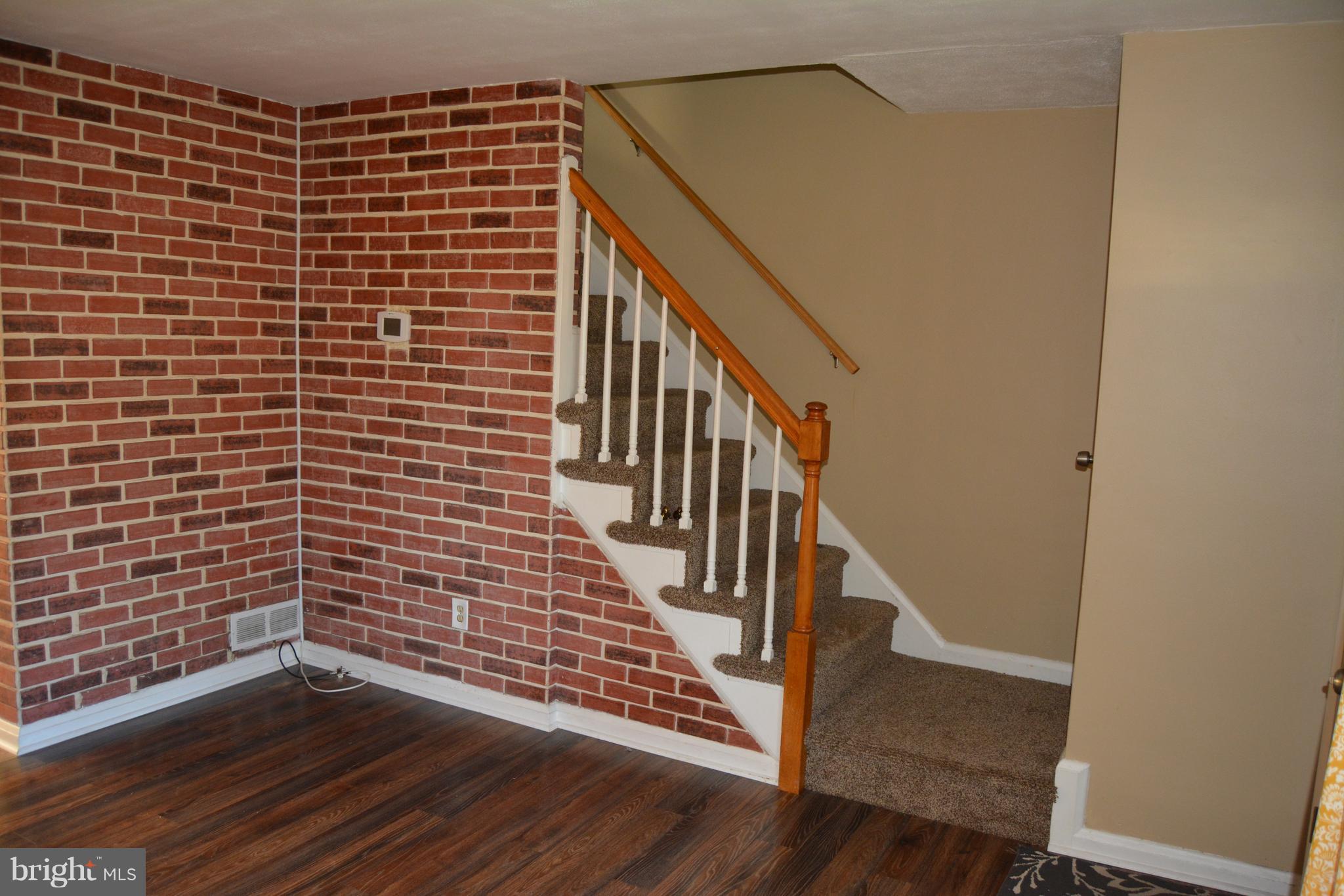 8004 Charlesmont Road Baltimore, MD 21222 - Photo 8 of 18 a view of wooden floor with staircase
