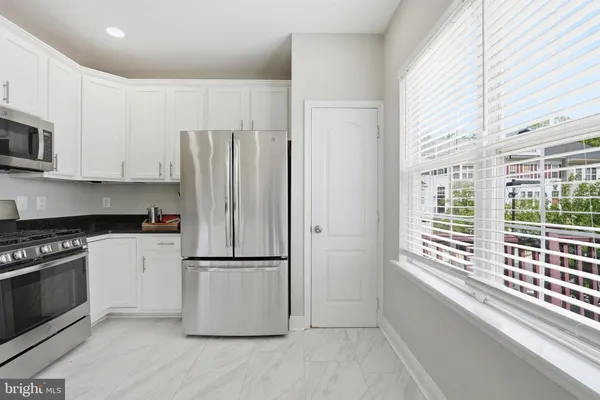 a kitchen with stainless steel appliances a stove a sink and a microwave