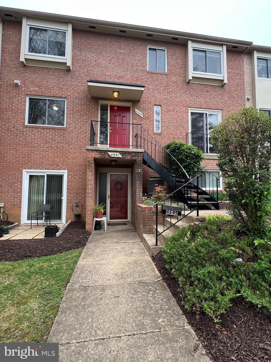 a front view of a house with garden and sitting area
