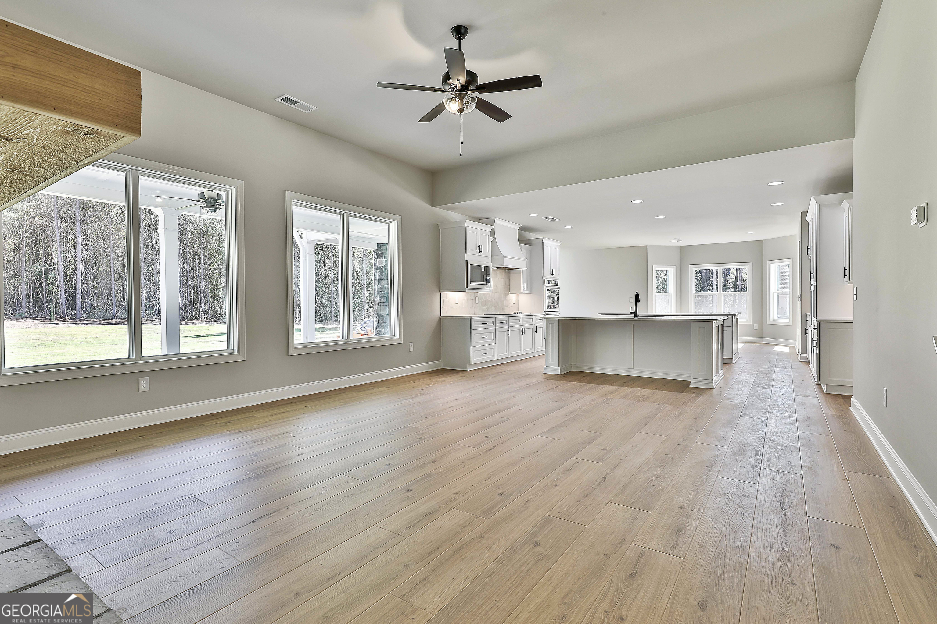 779 Alex Stephens Road Moreland, GA 30259 - Photo 12 of 54 a view of a kitchen with a stove cabinets a ceiling fan and wooden floor
