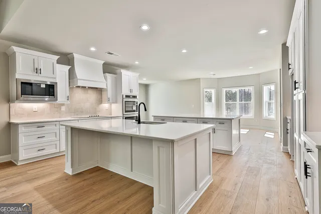 a kitchen with stainless steel appliances kitchen island granite countertop a sink and a microwave