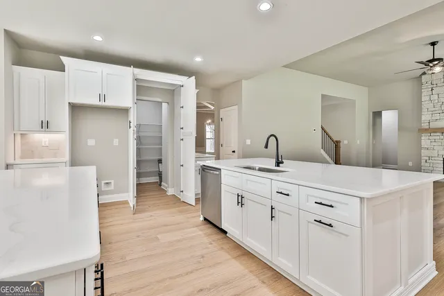 a large white kitchen with kitchen island and stainless steel appliances