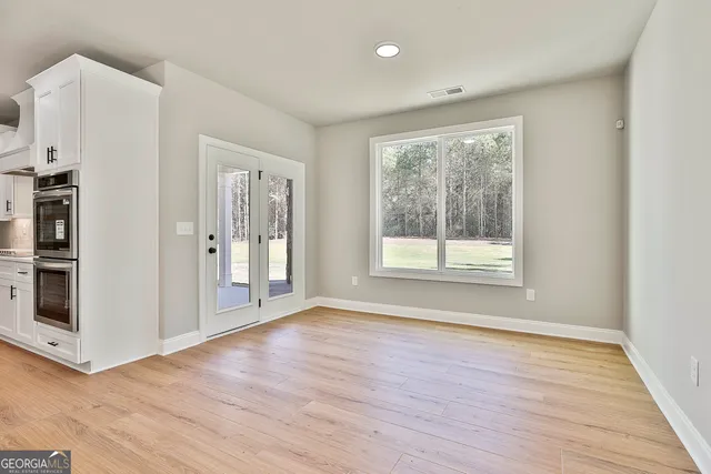 a view of a kitchen with wooden floor and a refrigerator