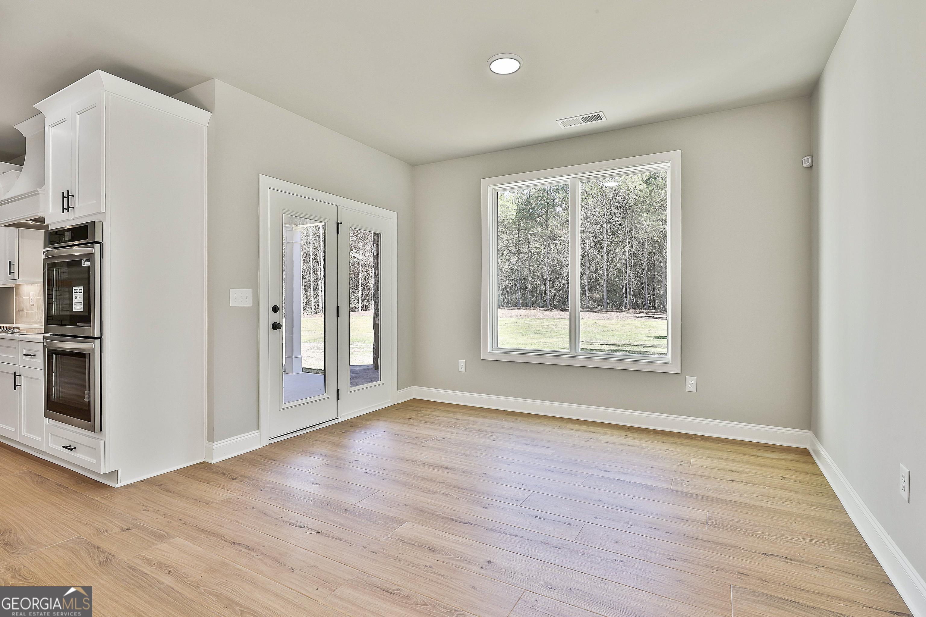 779 Alex Stephens Road Moreland, GA 30259 - Photo 26 of 54 a view of an empty room with wooden floor and a window