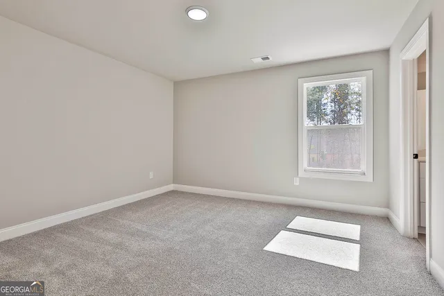 an empty room with windows and closet