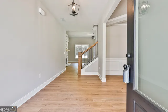 a view of a hallway with wooden floor and staircase