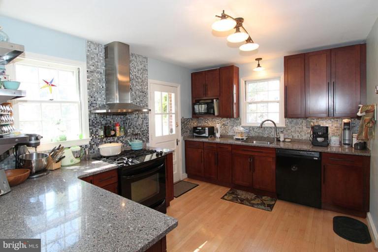 804 Rowen Road Silver Spring, MD 20910 - Photo 8 of 22 a kitchen with stainless steel appliances granite countertop a sink stove and refrigerator