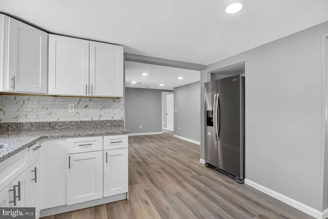 a view of granite countertop cabinets and wooden floor