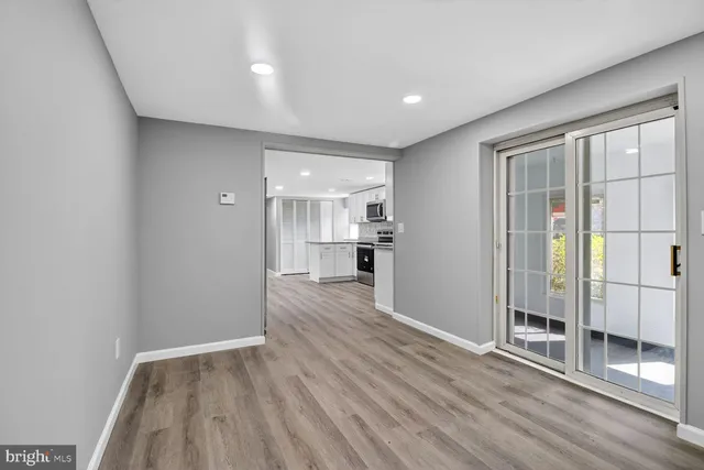 a view of a big room with wooden floor and windows
