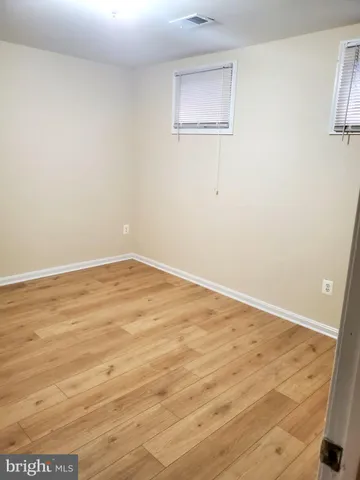 an empty room with wooden floor and closet