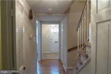 a view of a hallway with wooden floor and staircase