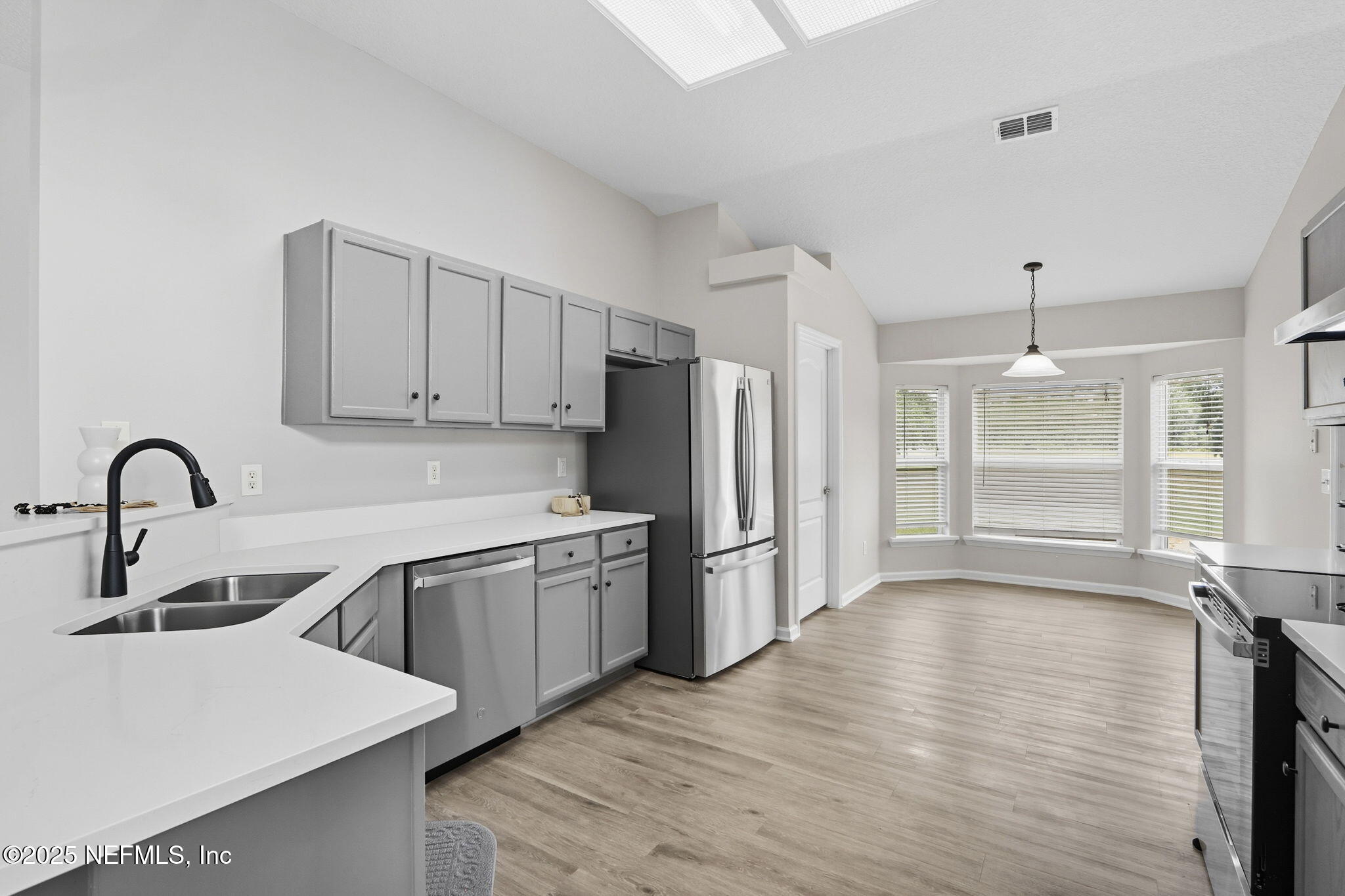 2064 Louie Carter Road Jacksonville, FL 32234 - Photo 23 of 46 a kitchen with stainless steel appliances granite countertop a refrigerator a sink dishwasher a stove and white countertops with wooden floor