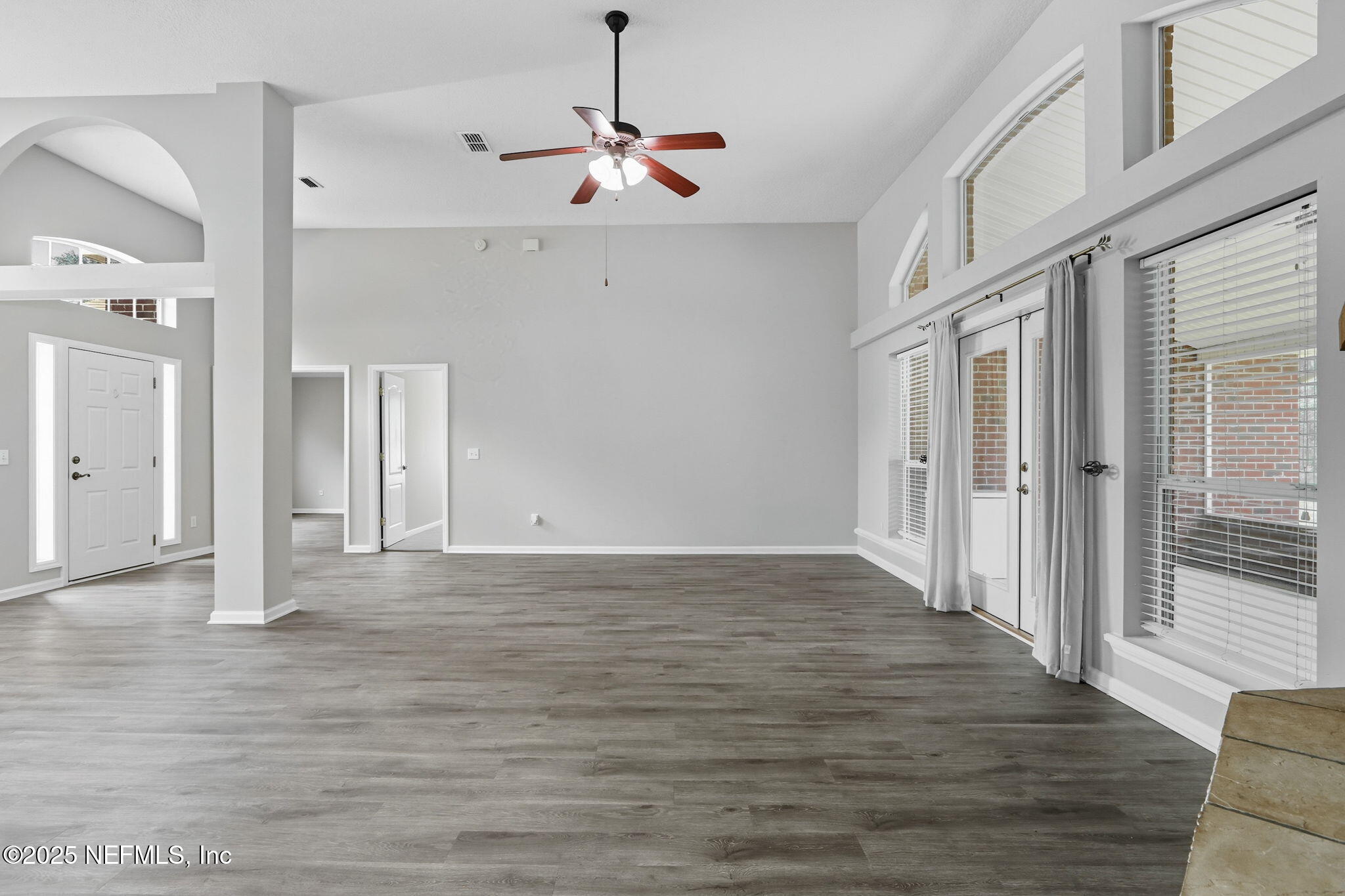 2064 Louie Carter Road Jacksonville, FL 32234 - Photo 26 of 46 a view of an empty room with wooden floor and a chandelier