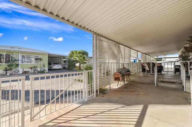 a view of a porch with chairs and potted plants