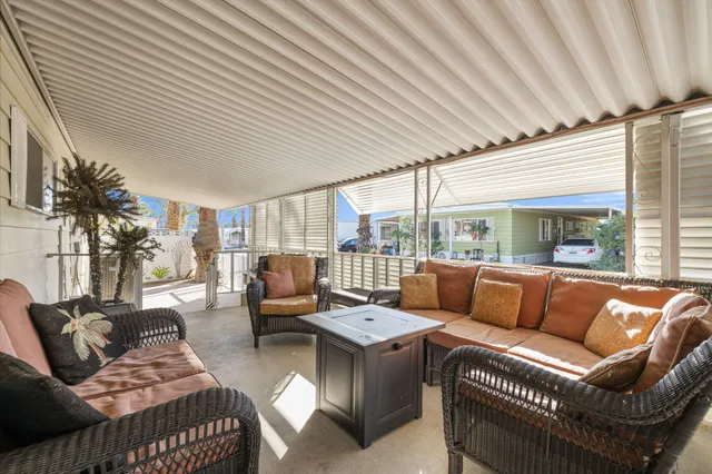 a living room with furniture a large window and a ceiling fan