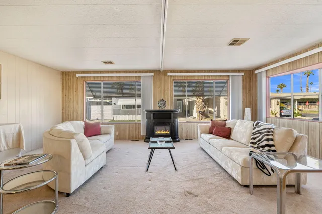 a living room with furniture a rug and a large window