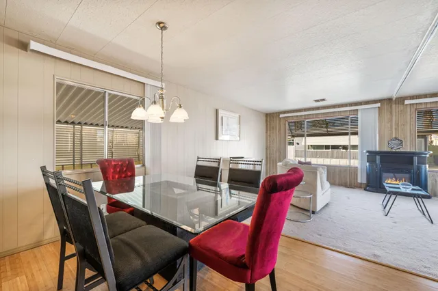 a dining room with furniture a chandelier and wooden floor