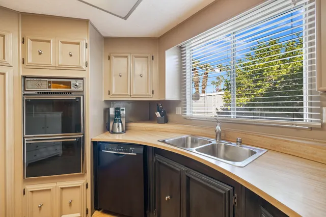 a kitchen with granite countertop a sink and a refrigerator
