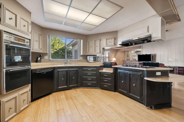 a kitchen with stainless steel appliances granite countertop a stove sink and cabinets