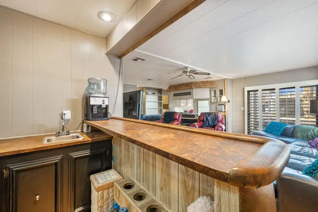 a view of a kitchen with kitchen island stainless steel appliances a sink and living room view