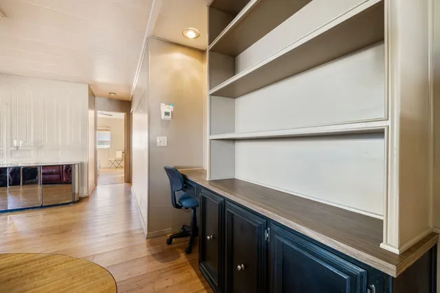 a hallway with a large window and wooden floor
