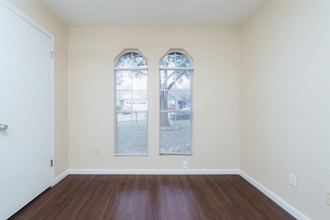 5603 Porsche Lane Austin, TX 78749 - Photo 11 of 25 an empty room with wooden floor chandelier and windows