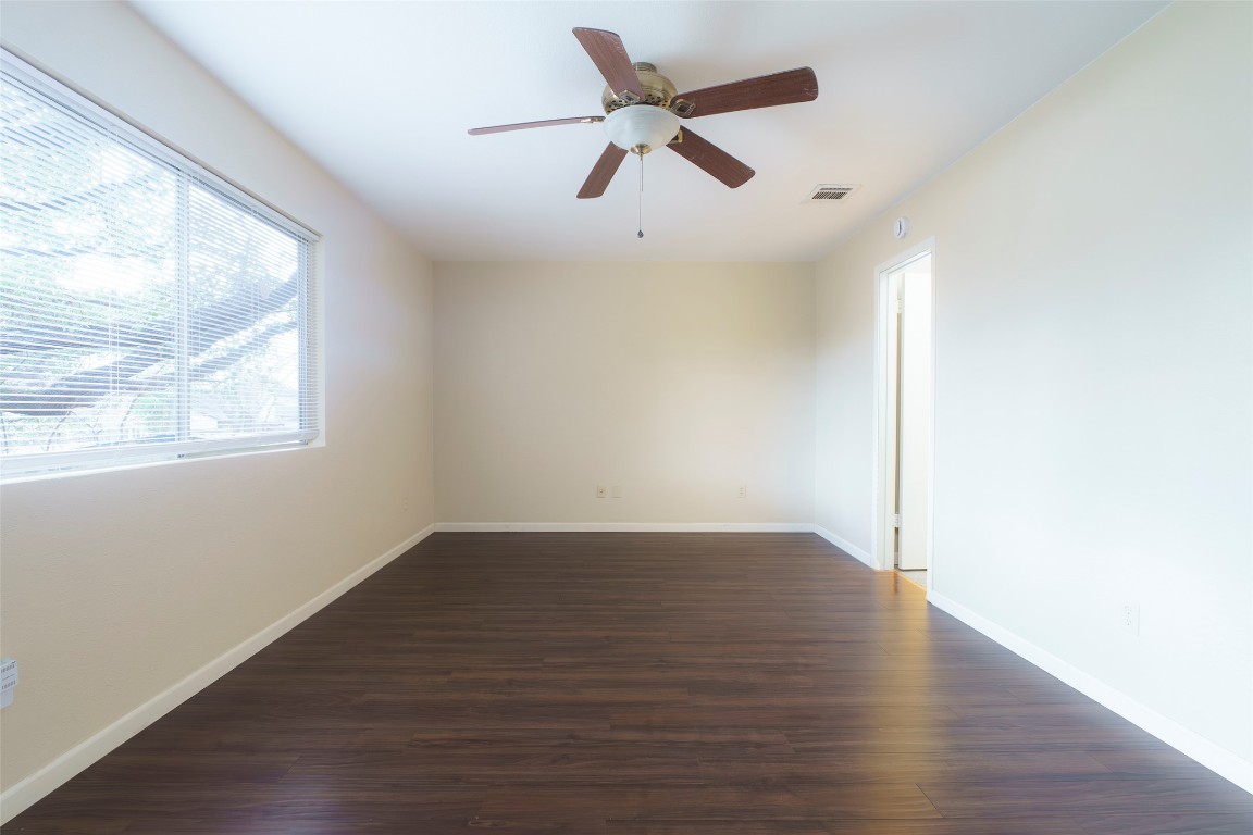 5603 Porsche Lane Austin, TX 78749 - Photo 13 of 25 an empty room with wooden floor fan and windows