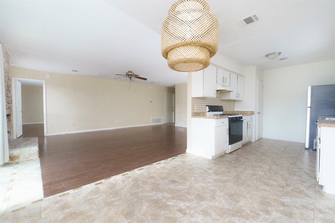 5603 Porsche Lane Austin, TX 78749 - Photo 5 of 25 a kitchen with stainless steel appliances granite countertop a sink a stove a refrigerator and a cabinets