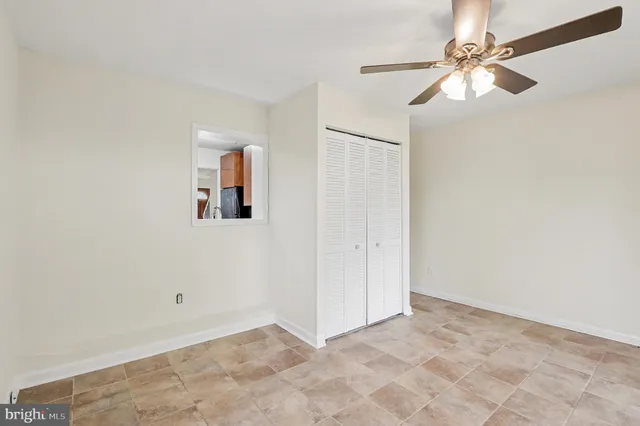 an empty room with windows and fan
