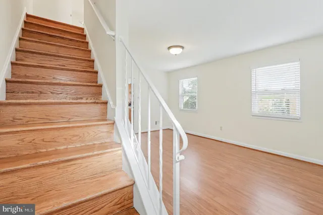 a view of staircase with wooden floor and white walls