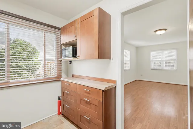 a view of a kitchen with wooden floor and a window