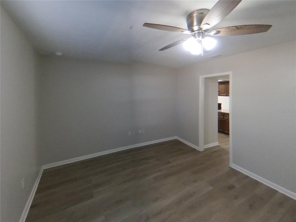 Undisclosed Address Brandon, FL 33510 - Photo 2 of 17 an empty room with wooden floor and fan