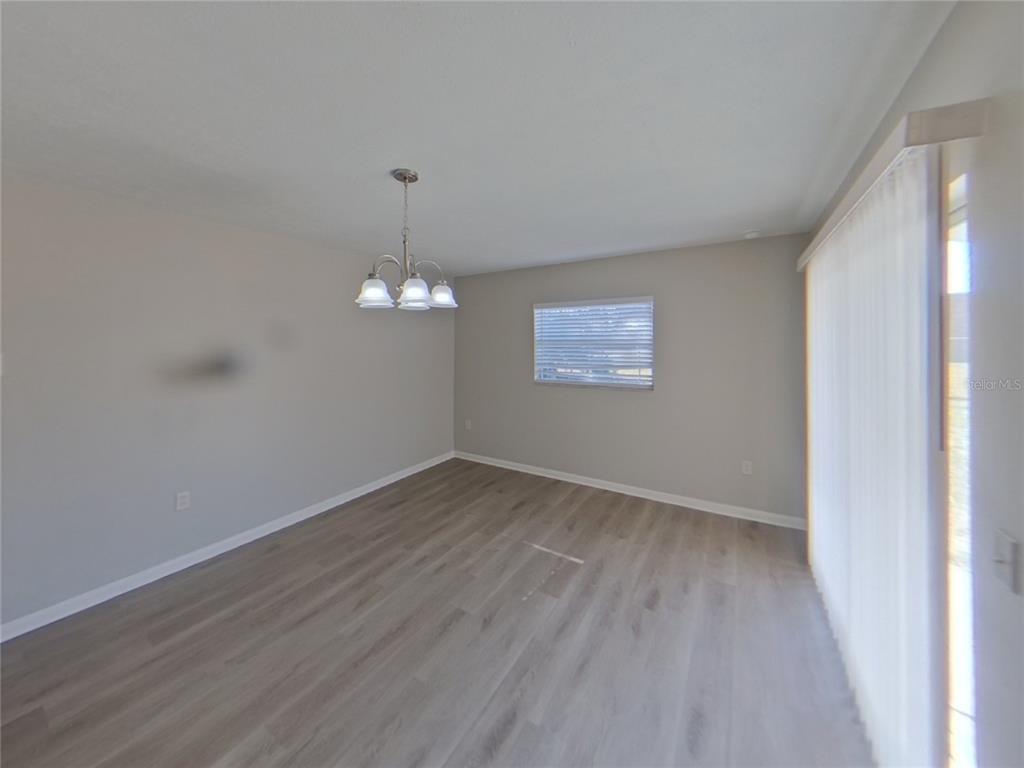 Undisclosed Address Brandon, FL 33510 - Photo 4 of 17 a view of an empty room with wooden floor and a window