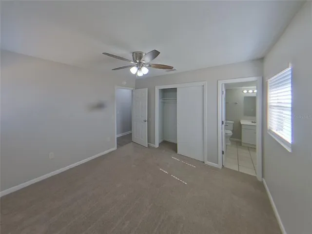 a view of an empty room with a chandelier fan