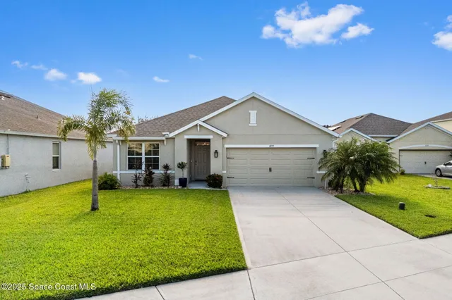 a view of a house with a yard and garage