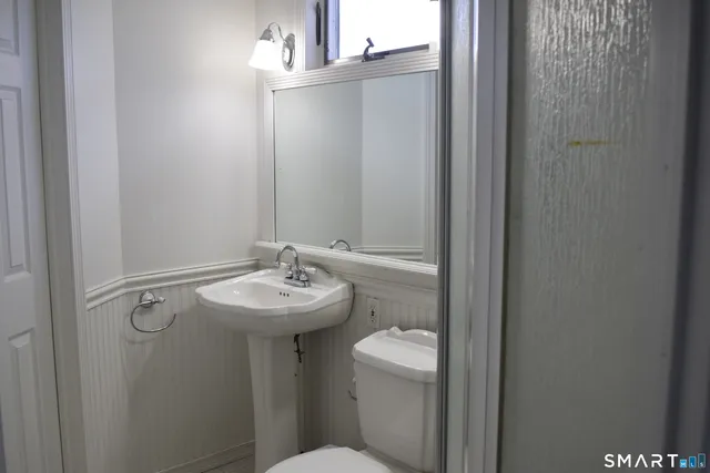 a bathroom with a sink toilet and a mirror