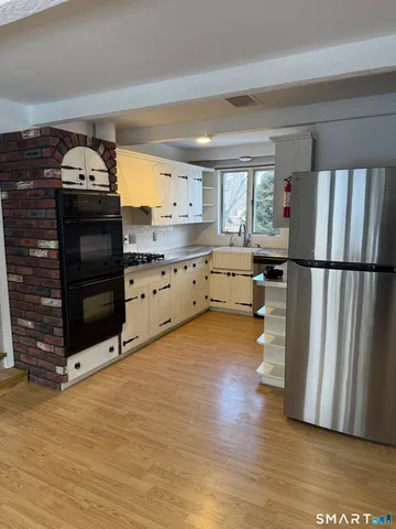 a kitchen with stainless steel appliances a stove cabinets and wooden floor