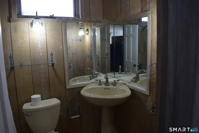 a bathroom with a toilet sink and mirror