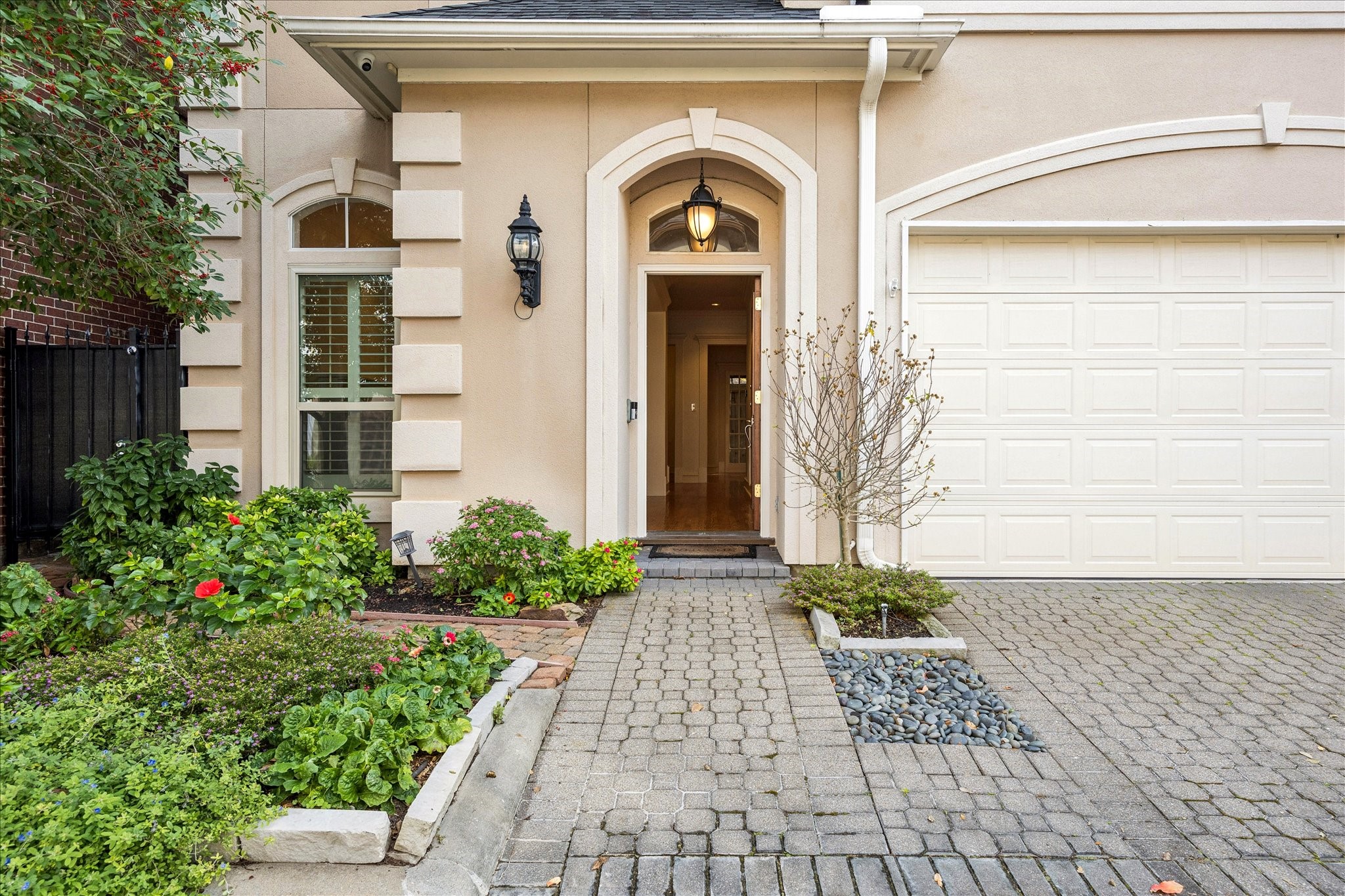5823 Augusta Court Houston, TX 77057 - Photo 2 of 44 This charming home features a welcoming entrance with a stylish arched doorway and elegant exterior lighting. A well-maintained garden and paved walkway enhance curb appeal, complemented by a spacious garage.