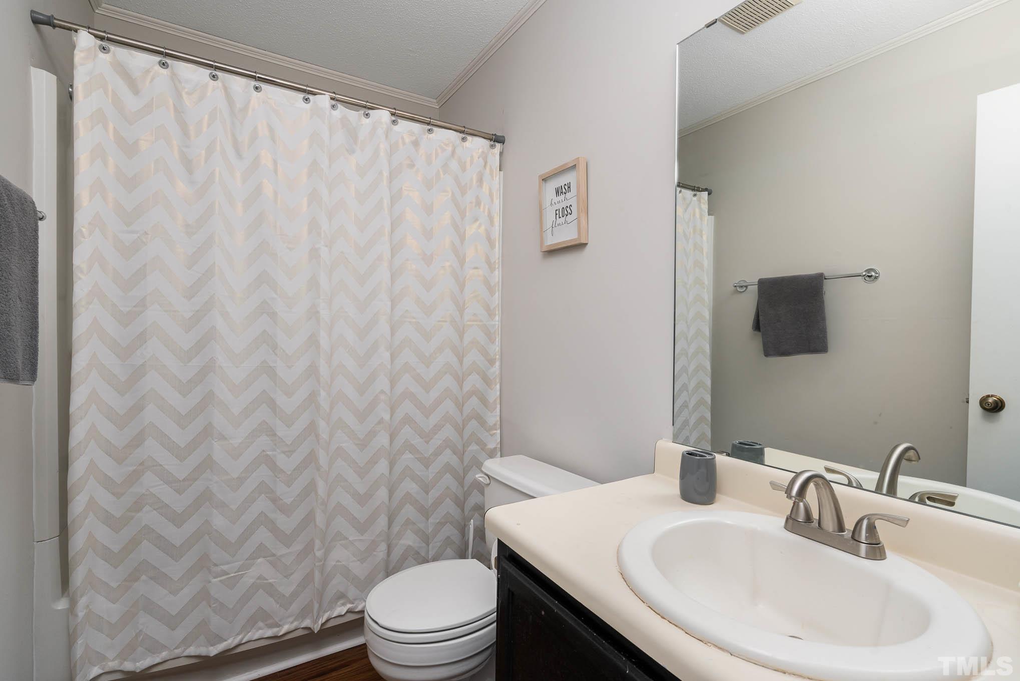 4701 Courtside Place Raleigh, NC 27604 - Photo 15 of 30 a bathroom with a sink a toilet and shower curtain