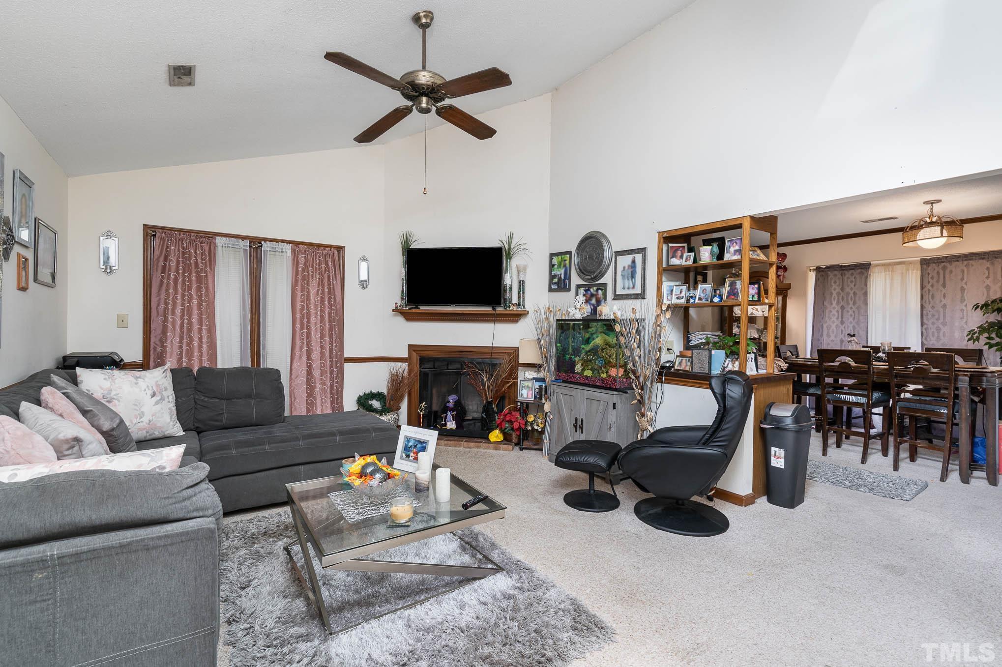 4701 Courtside Place Raleigh, NC 27604 - Photo 18 of 30 a living room with furniture a fireplace and a flat screen tv